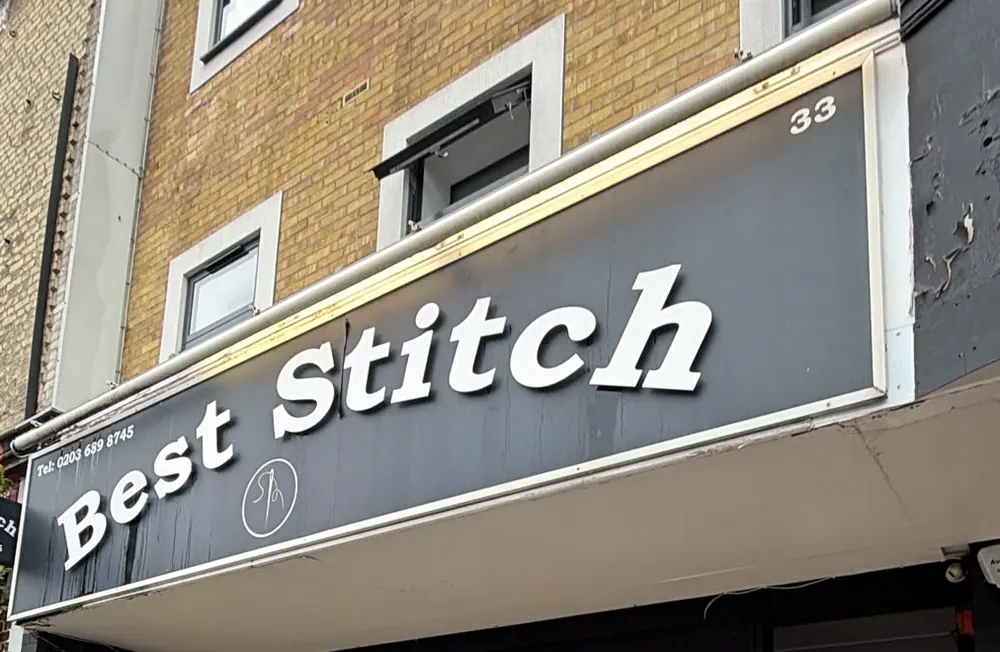The Best Stitch shop sign, white lettering on a black fascia above number 33 Widmore Road